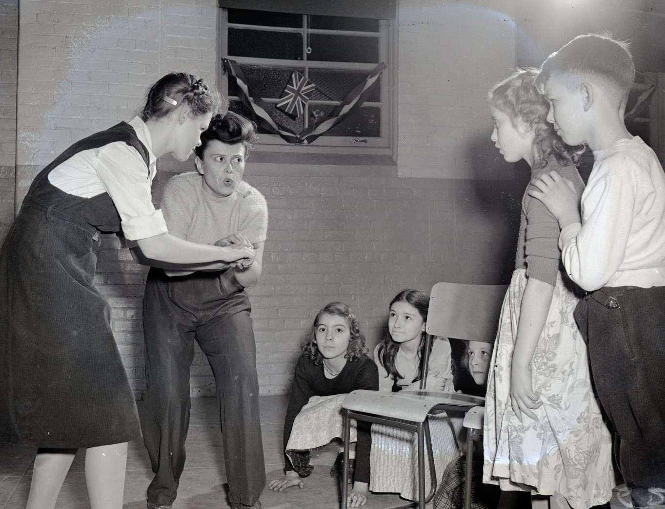 A teacher giving game instruction to students listening carefully.