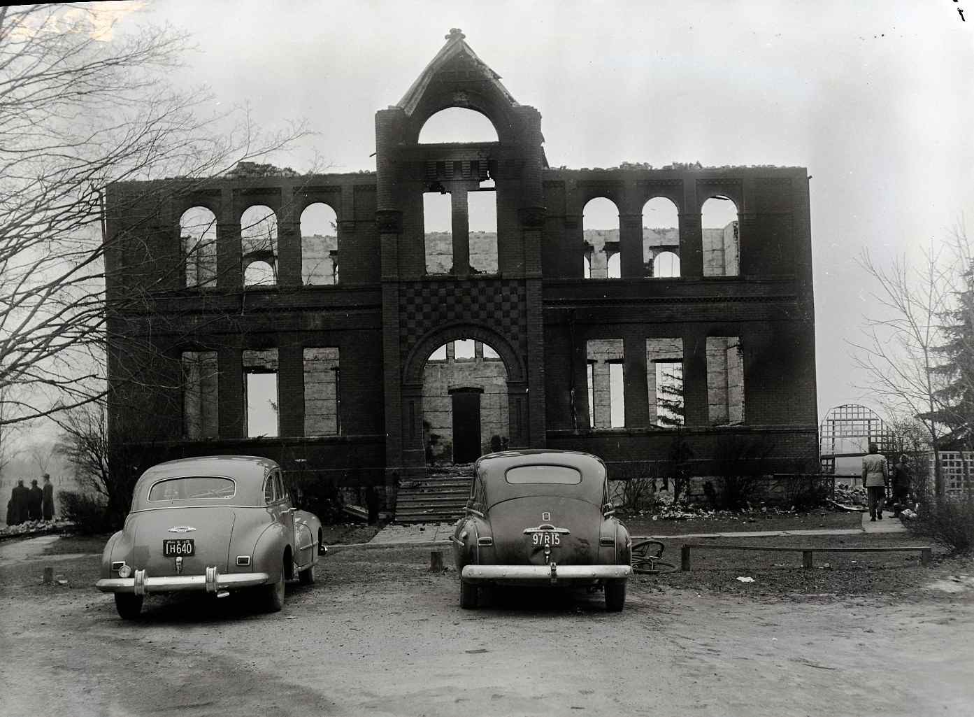 Cars parked in front of the ruins of the Princeton School after it was destroyed by fire.