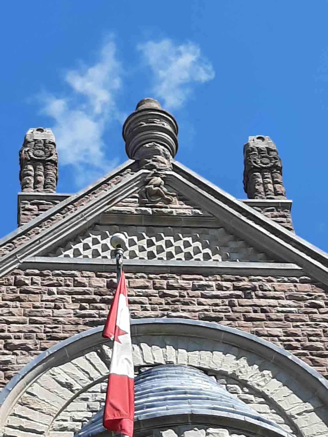 Monkey carved into the County Courthouse stone at the top of the building. The monkey carving appears to be climbing to the top.