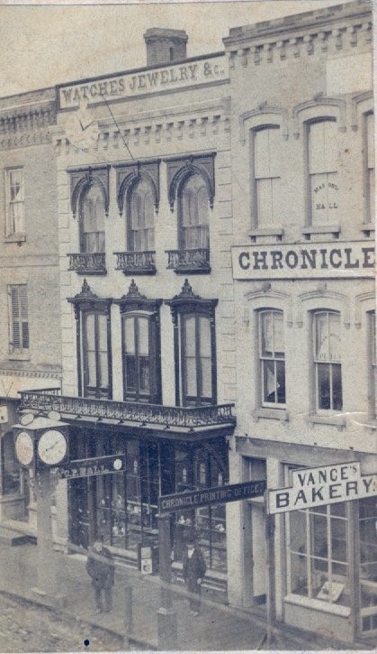 A street view of downtown Ingersoll showing the brick building that housed Vance's bakery. A bakery sign is on the front of the building.