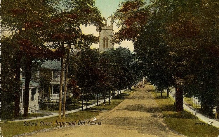 A colourized postcard showing a street view of Oxford Street in Ingersoll. The street is lined with houses.