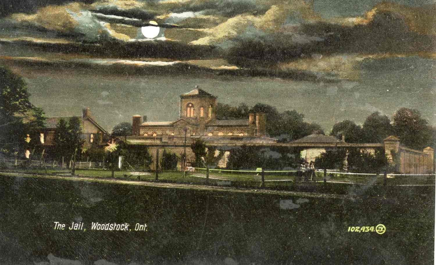 A colourized postcard of the Oxford County Gaol at night. 