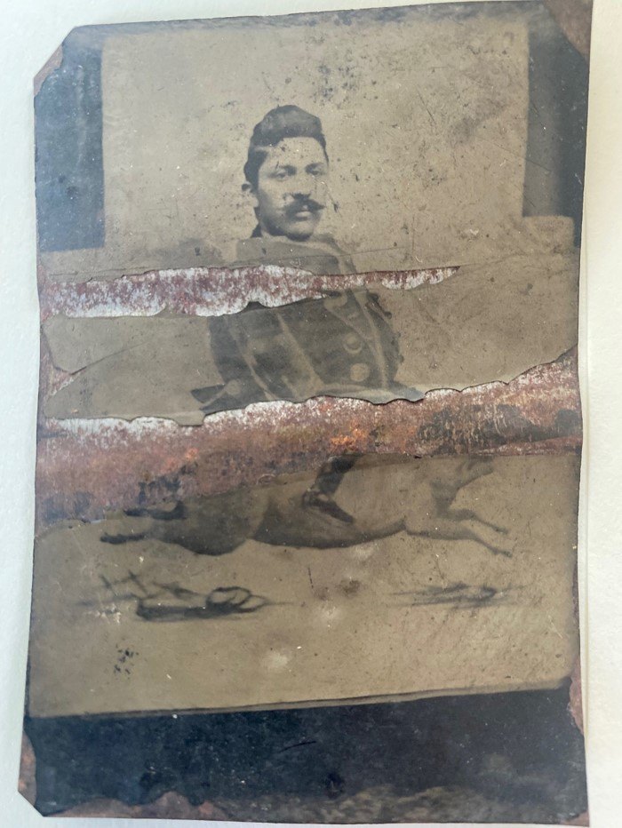 A manipulated tintype photo of a man riding a a pig.