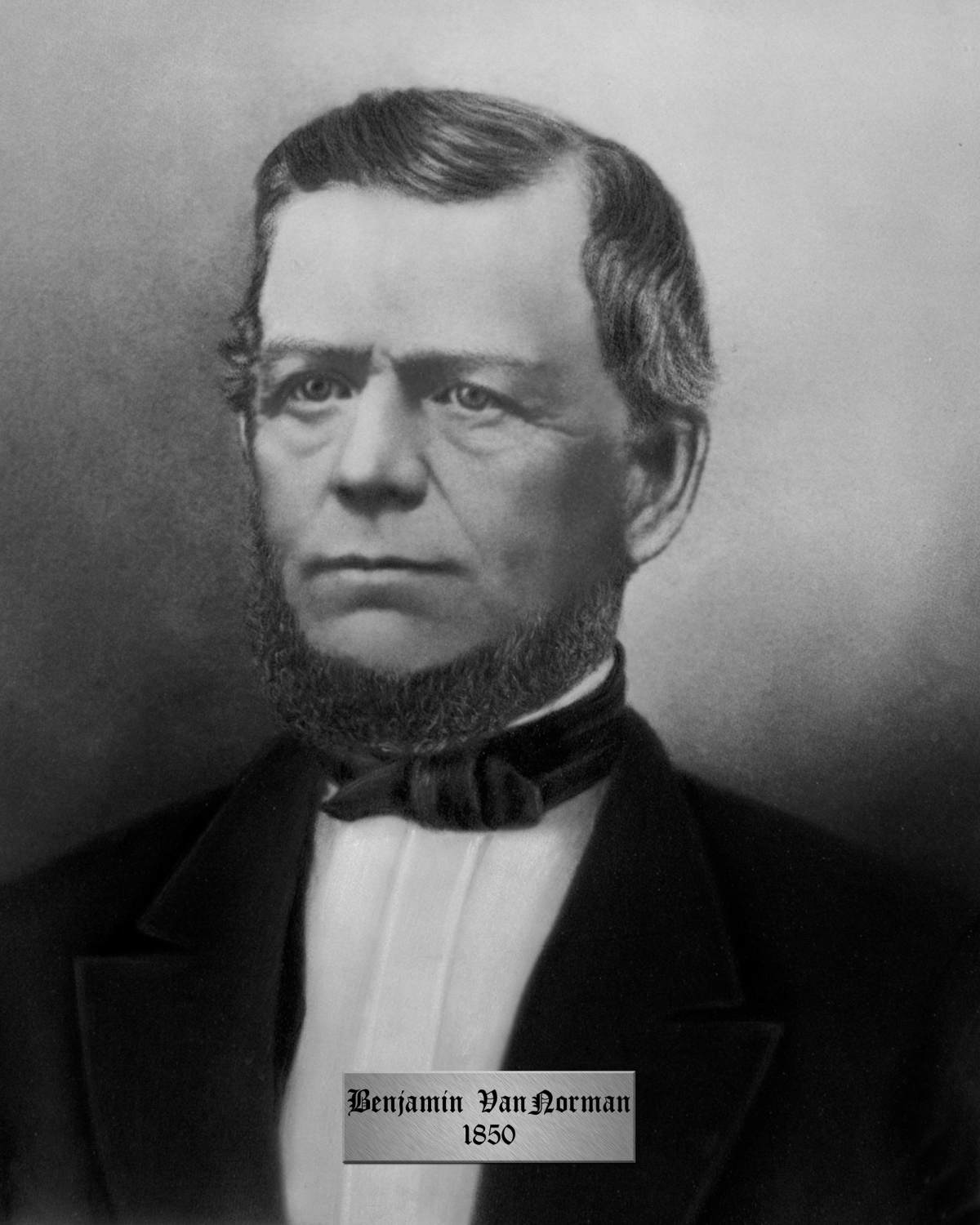 A portrait of District of Brock Warden Benjamin Van Norman, who was also an Oxford County Warden in 1850. Van Norman is wearing a a dark suit with a white shirt underneath and a bowtie. He has a short beard on his face.