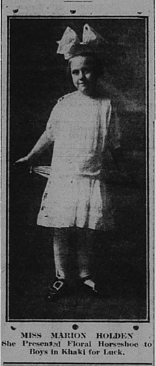 Newspaper photograph of Marion Holden wearing a light coloured dress and a huge bow on top of her head.