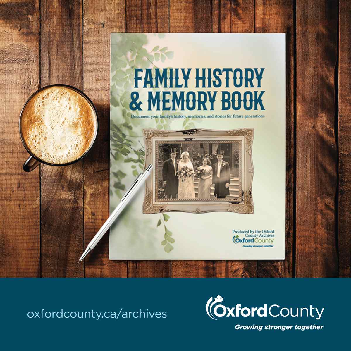 An image of the Family History & Memory Book from the Archives. The book cover is light green with pale green leaves decorated the left side. In the centre of the cover is an old wedding portraits from the 1920s surrounded by an antique weathered frame. At the top of the cover there is blue text that reads: Family History & Memory Book. Document your family's history, memories, and stories for future generations. The book is sitting on a wooden table. The left of the book on the table is a cup of coffee and a silver pen.