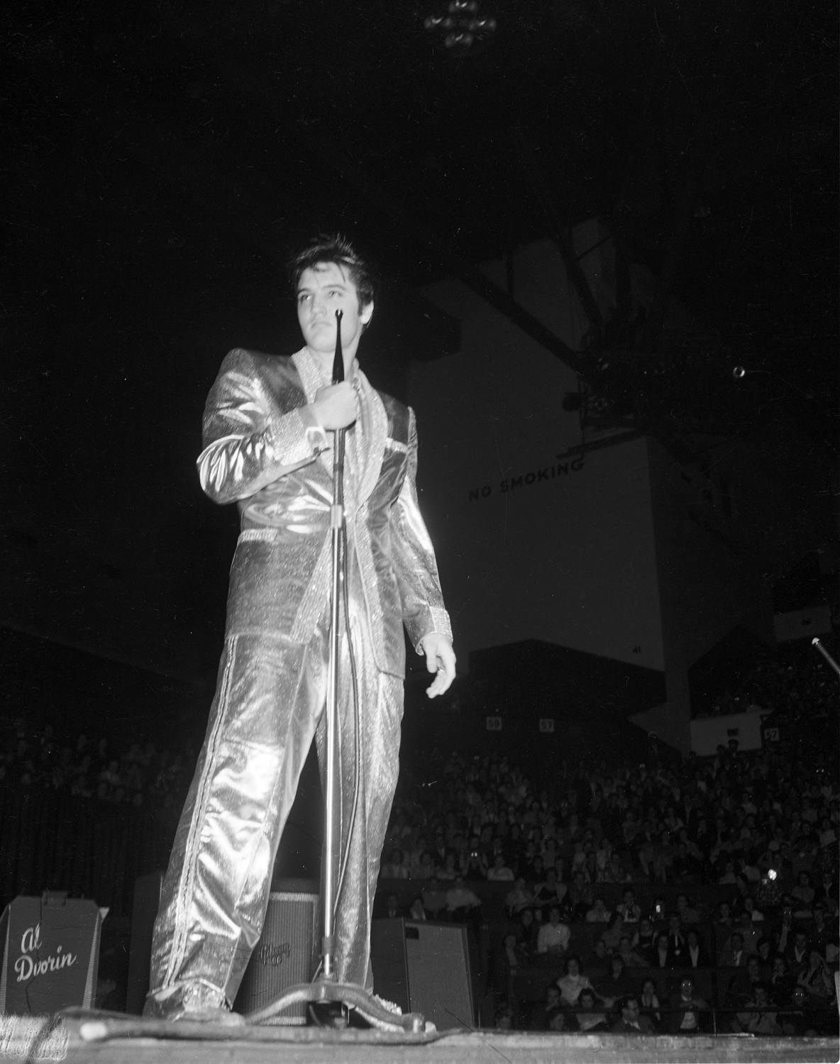 A photograph of Elvis Presley performing on stage.