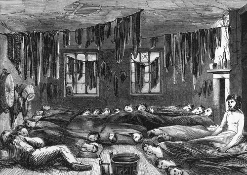 An 1850 engraving depicting cramped and squalid housing conditions in London. There is a large group of people cramped into one room, the room is dark. Many men, women, and children are sleeping on the floor. Clothing is hanging from lines on the ceiling. The building looks run down and dirty.